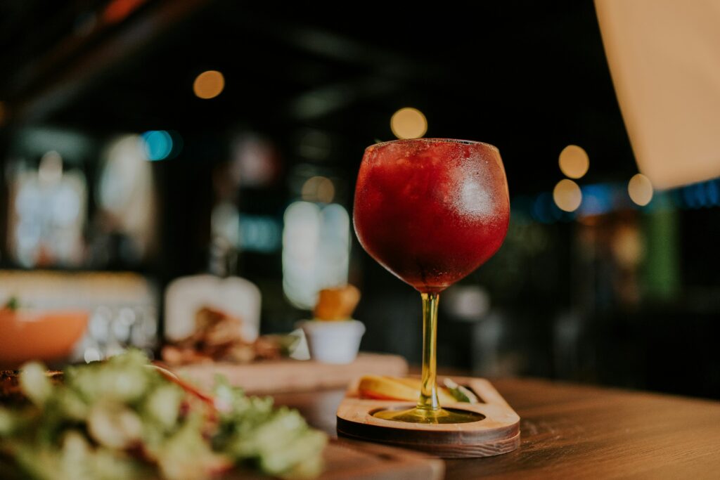 Refreshing chilled red cocktail in glass, perfect for a relaxing evening indoors.